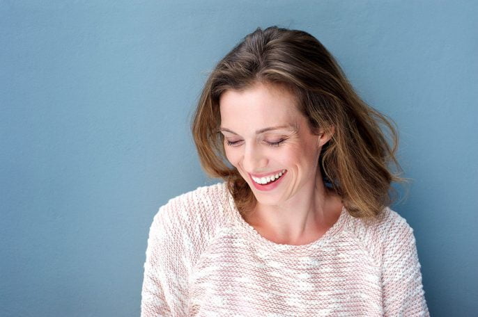 woman-laughing-blue-background