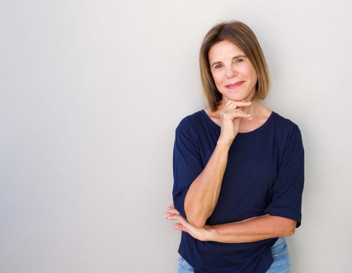 proud woman standing with chin resting on her hand 