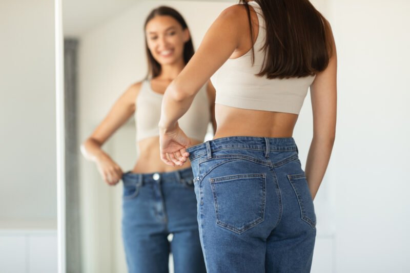 Woman trying on jeans in the mirror
