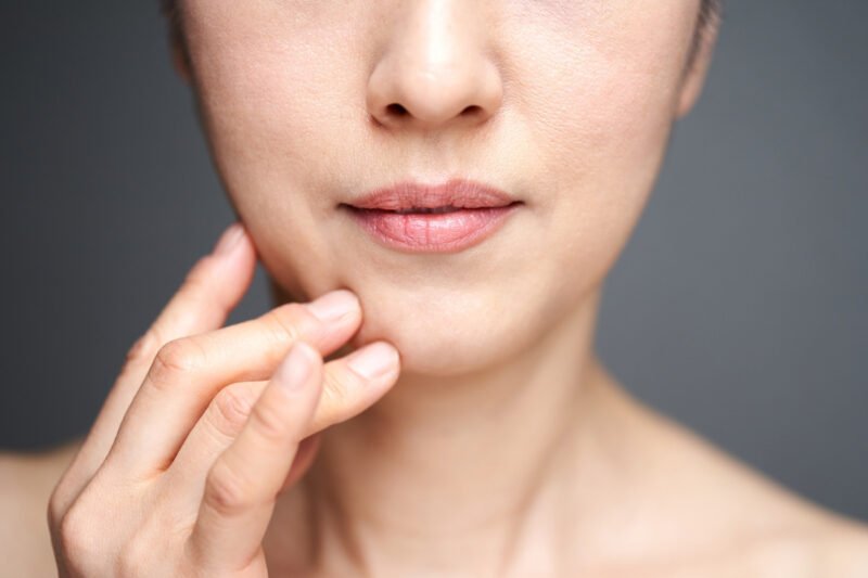 Woman touching skin on face 