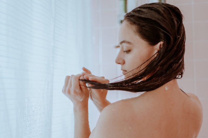 Woman taking a shower using rice water for hair care