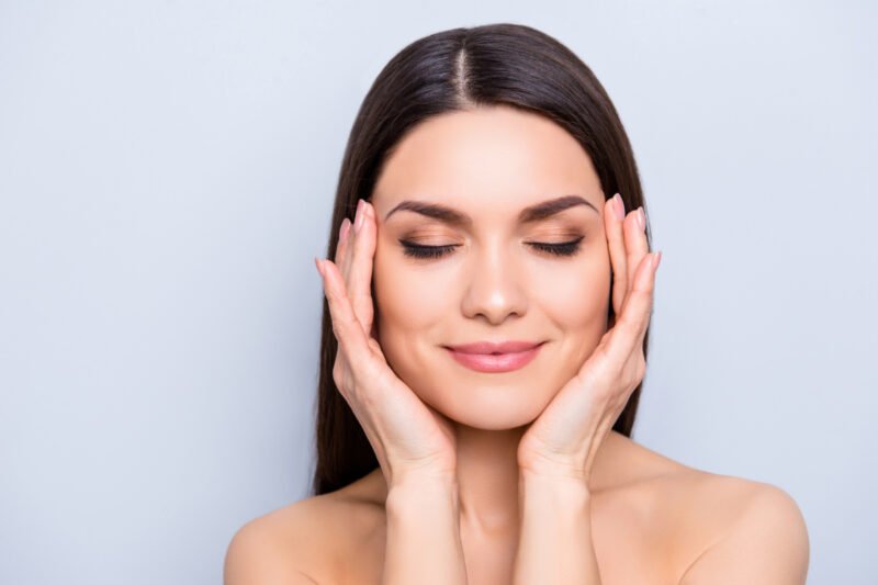 Woman touching rejuvenated skin after med spa treatments